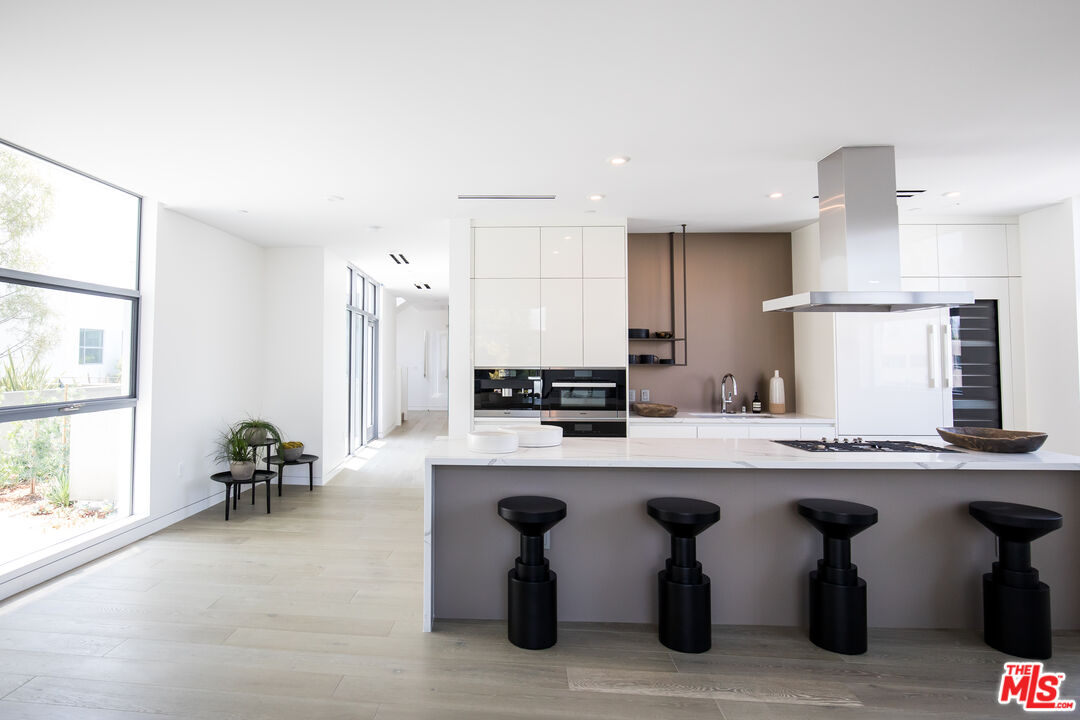 8600 Wilshire Boulevard, Unit PH17 Beverly Hills, CA 90211 - Photo 8 of 32 a kitchen with cabinets table and chairs