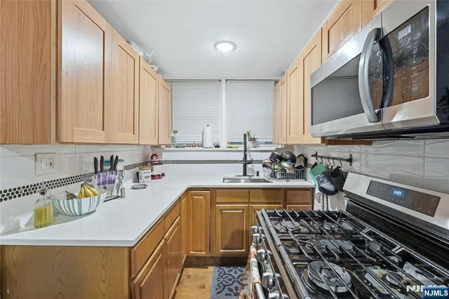 a kitchen with a stove a sink white cabinets and a refrigerator