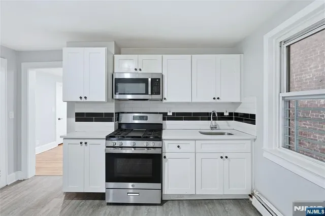a bathroom with a bathtub a shower a sink and a window