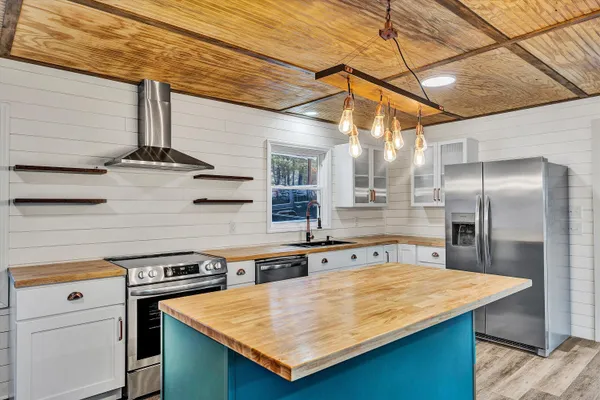 a kitchen with stainless steel appliances granite countertop a sink a stove and refrigerator