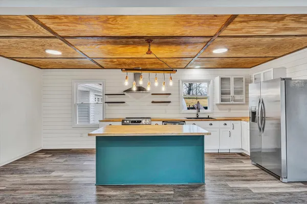 a kitchen with kitchen island a sink stove and refrigerator
