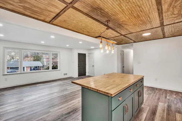 a kitchen with a stove and wooden floor