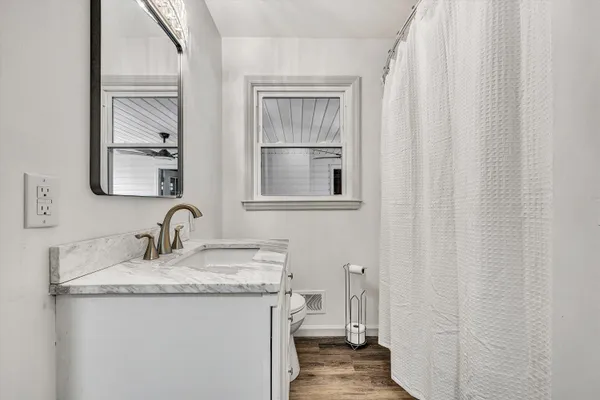a bathroom with a granite countertop sink and a mirror