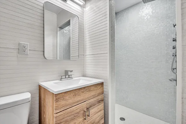 a bathroom with a sink a toilet and shower