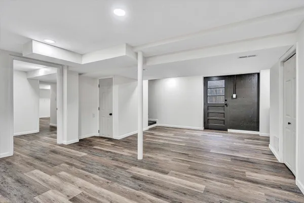 a view of an empty room with wooden floor and closet