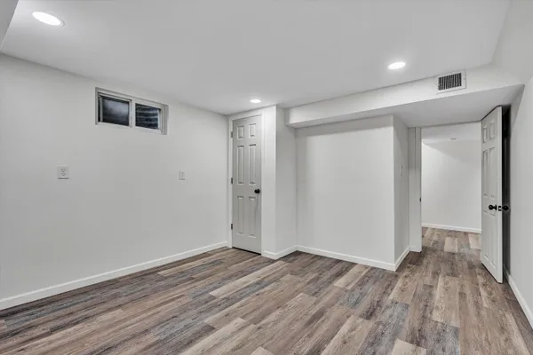 a view of empty room with wooden floor