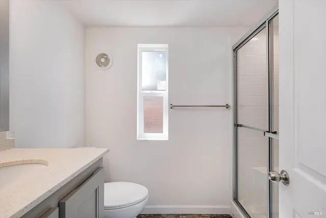 a bathroom with a granite countertop sink toilet and shower
