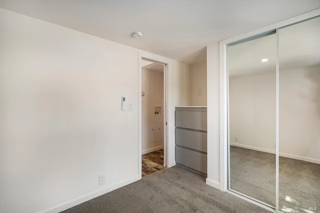 an empty room with closet and wooden floor