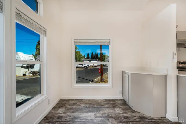 a view of a hallway to a livingroom with furniture and window