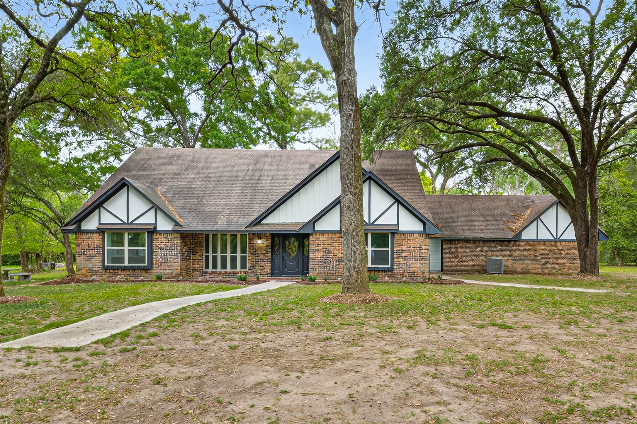 23607 Cardinal Drive Hockley, TX 77447 - Photo 1 of 50 Tucked away among a canopy of mature trees, the home’s charming exterior emerges like a storybook scene, perfectly integrated into its lush acreage.