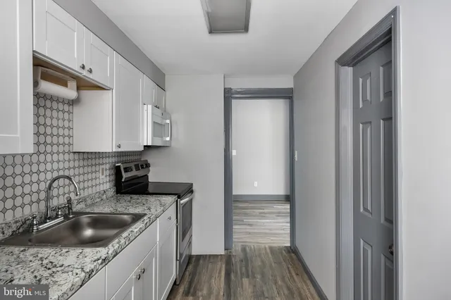 a kitchen with stainless steel appliances granite countertop a sink stove and cabinets