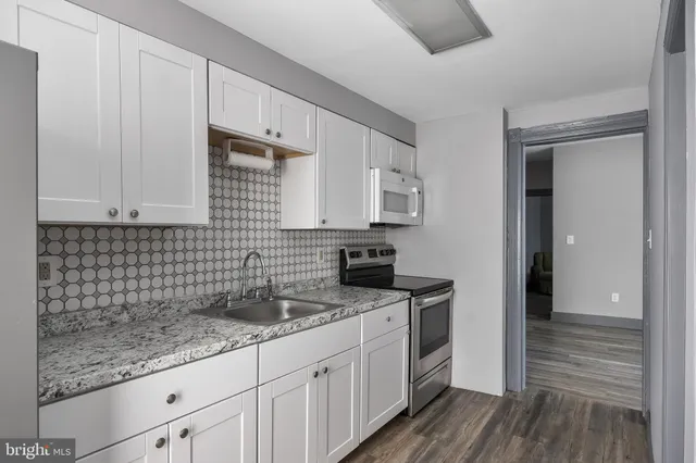 a kitchen with stainless steel appliances granite countertop a sink stove and cabinets