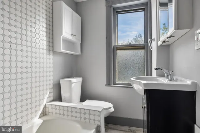 a bathroom with a toilet a sink and mirror