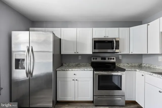 a kitchen with white cabinets stainless steel appliances and sink