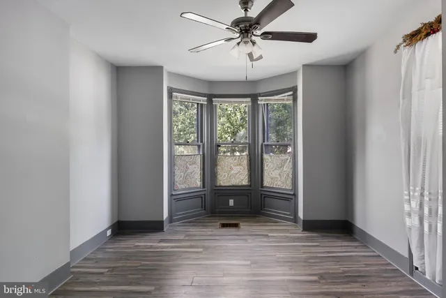 a view of room with wooden floor and ceiling fan