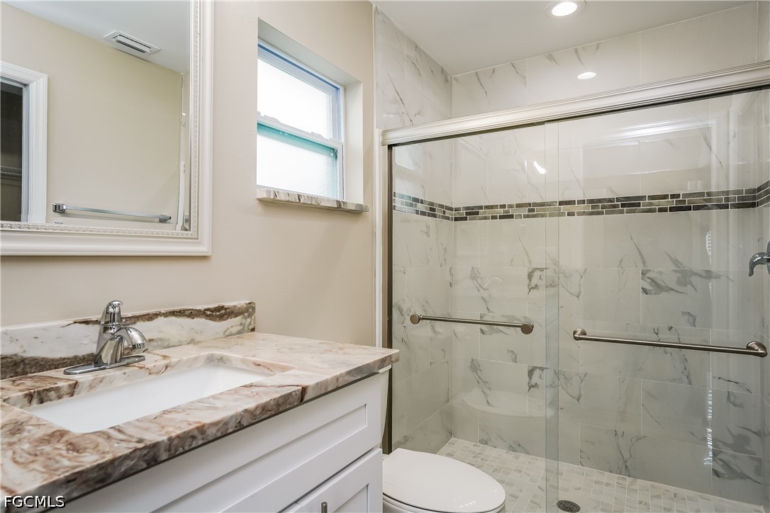 3707 10th Street Southwest Lehigh Acres, FL 33976 - Photo 11 of 15 a bathroom with a granite countertop sink toilet and shower