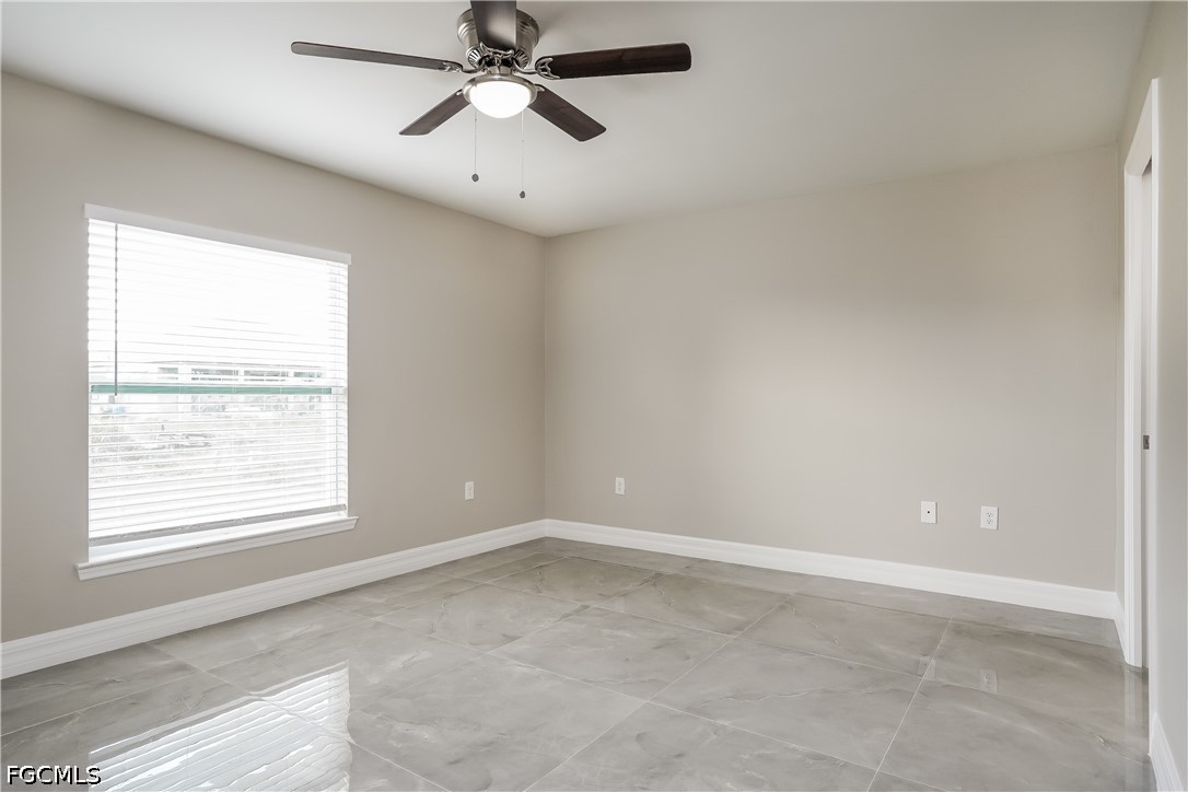 3707 10th Street Southwest Lehigh Acres, FL 33976 - Photo 12 of 15 an empty room with a window and a fan