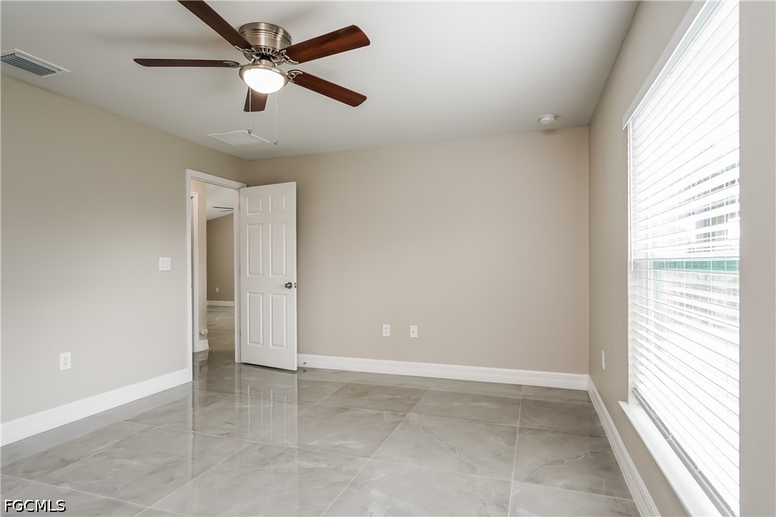 3707 10th Street Southwest Lehigh Acres, FL 33976 - Photo 13 of 15 an empty room with a window and a fan