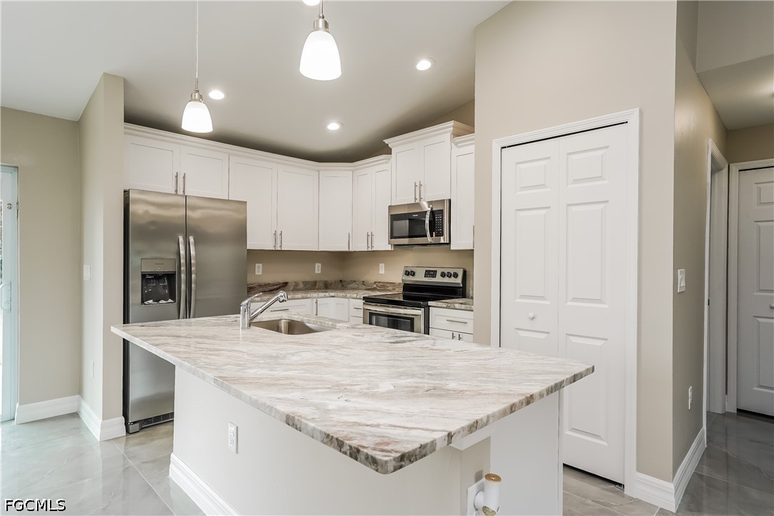 3707 10th Street Southwest Lehigh Acres, FL 33976 - Photo 4 of 15 a kitchen with kitchen island a sink stainless steel appliances and refrigerator