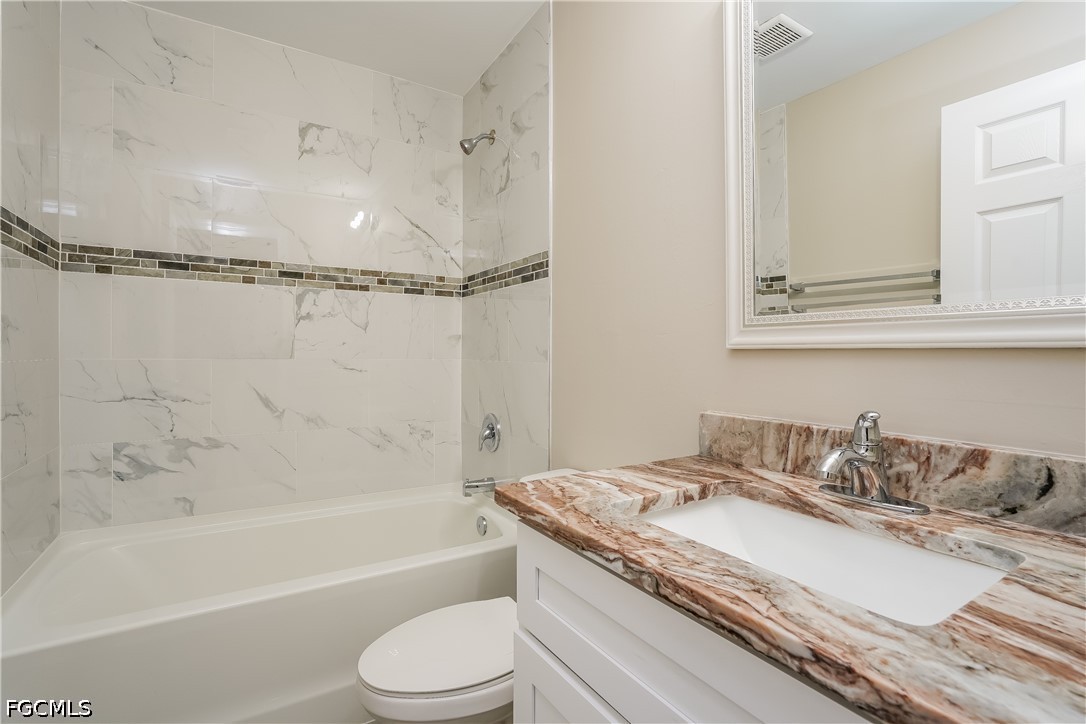 3707 10th Street Southwest Lehigh Acres, FL 33976 - Photo 8 of 15 a bathroom with a granite countertop sink a toilet and bathtub