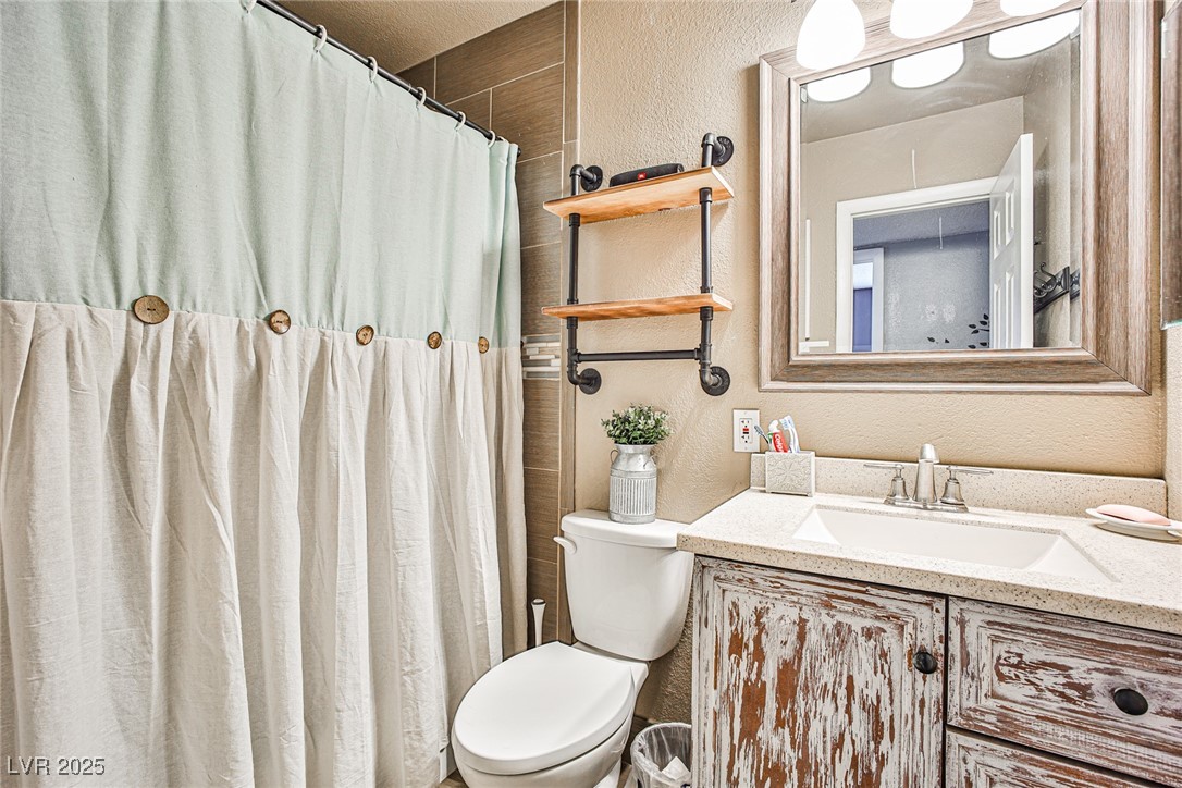 2540 Eagle Street Las Vegas, NV 89142 - Photo 11 of 29 Bathroom featuring curtained shower, a textured wa