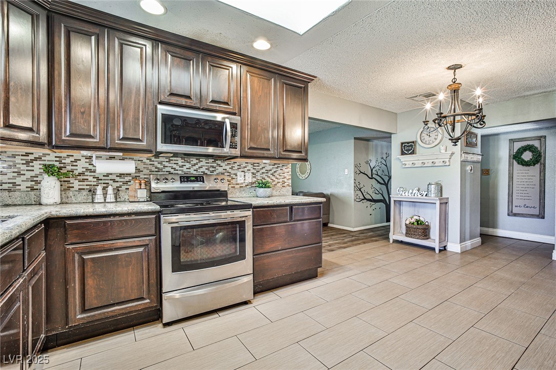 2540 Eagle Street Las Vegas, NV 89142 - Photo 14 of 29 Kitchen with a notable chandelier, dark brown cabi