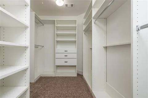 a view of walk in closet with empty racks