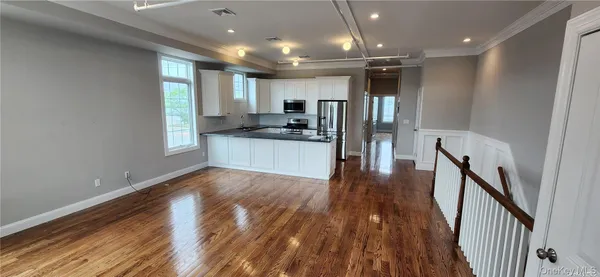 a view of a kitchen with a sink and wooden floor