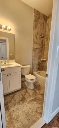 a bathroom with a sink a toilet a mirror and shower
