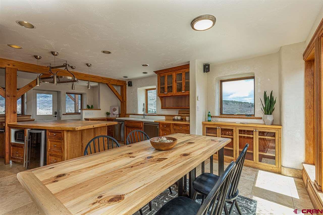 2529 County Road 124 Mancos, CO 81328 - Photo 13 of 34 a dining room with stainless steel appliances kitchen island granite countertop a stove a sink a dining table and chairs with wooden floor