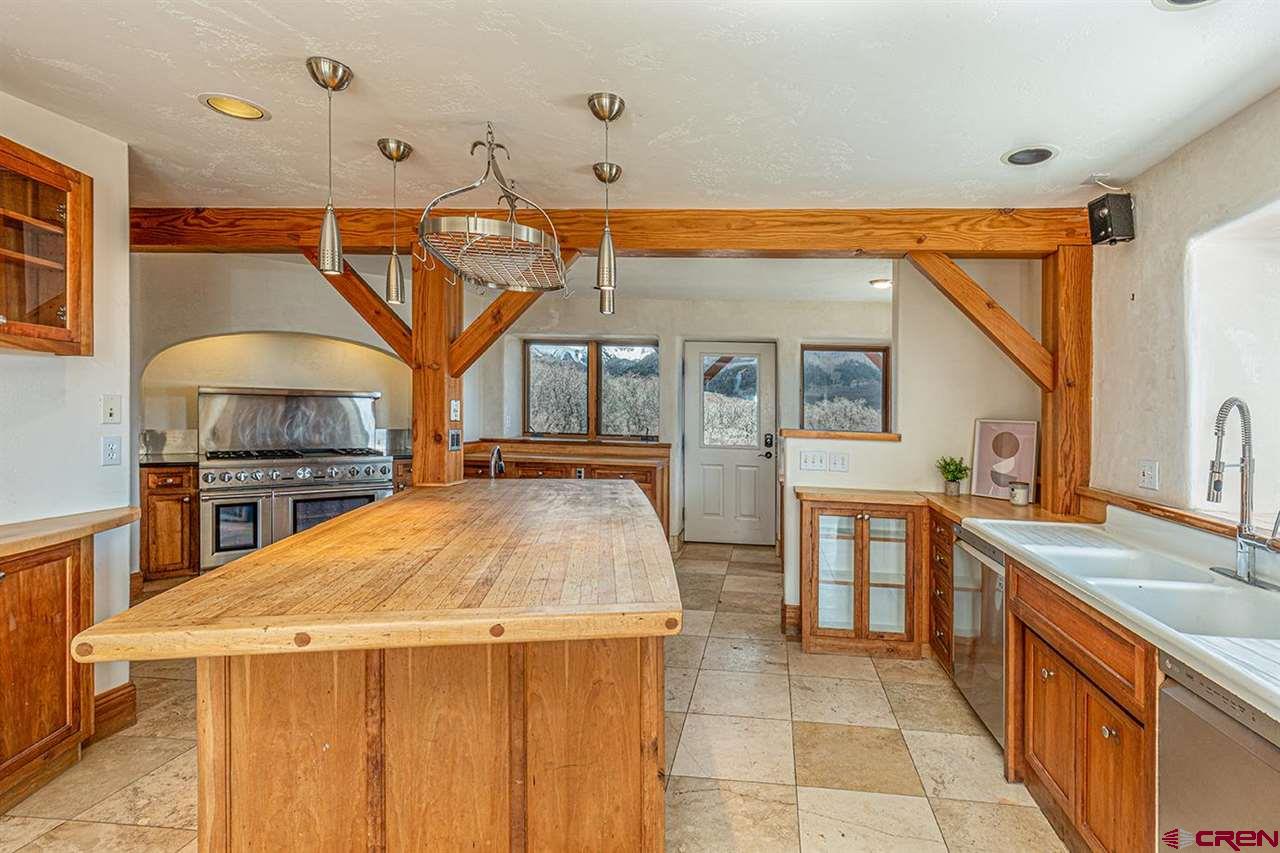 2529 County Road 124 Mancos, CO 81328 - Photo 14 of 34 a kitchen with stainless steel appliances kitchen island granite countertop a sink and cabinets