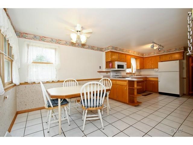 8400 South Kenneth Avenue Chicago, IL 60652 - Photo 5 of 16 a kitchen with a sink a stove a table and chairs