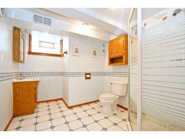 8400 South Kenneth Avenue Chicago, IL 60652 - Photo 7 of 16 a bathroom with a toilet a sink a mirror and shower