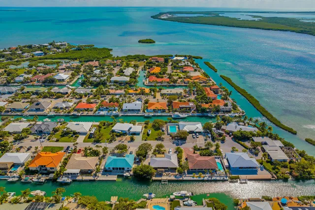 an aerial view of a city with lots of residential buildings ocean and mountain view in back