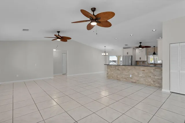 an empty room with kitchen view