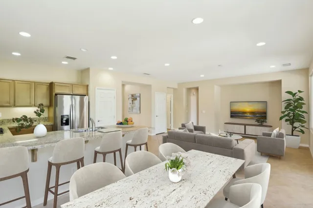 a living room with furniture kitchen view and a flat screen tv
