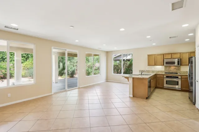 a kitchen with stainless steel appliances granite countertop a sink and a refrigerator