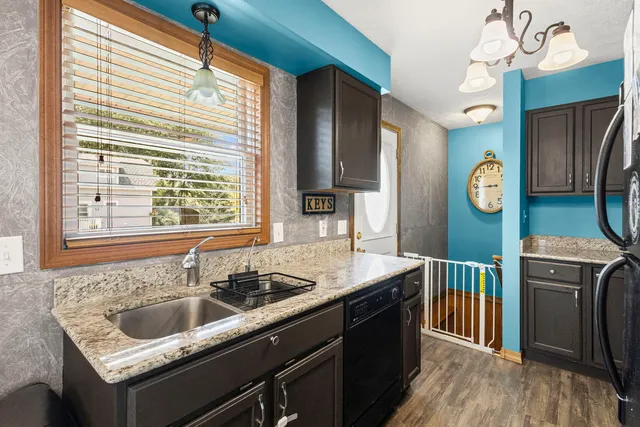 a kitchen with granite countertop a sink a counter space and stainless steel appliances