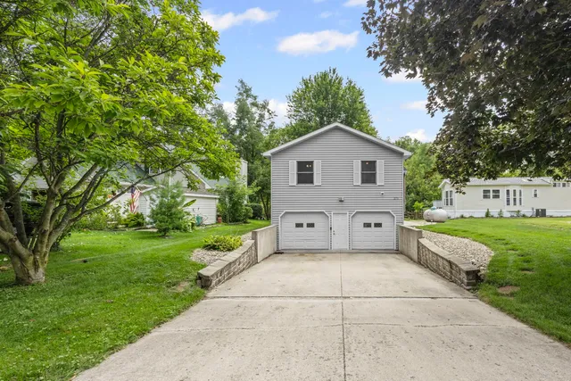 a view of a house with a yard and a large tree