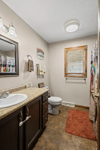 a spacious bathroom with a granite countertop sink and a mirror