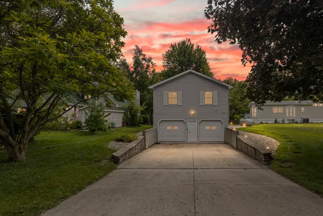 a front view of a house with a yard and trees