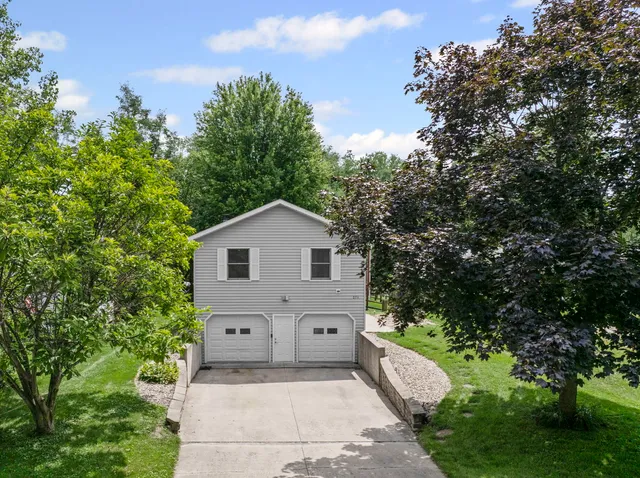 a front view of a house with a yard and trees