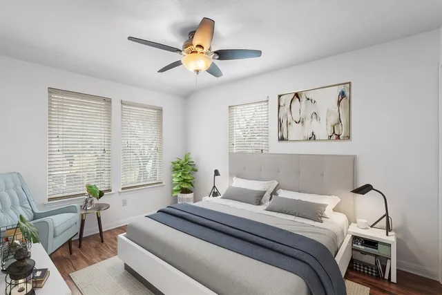 a bedroom with a bed and a large window