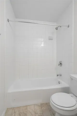 a bathroom with a toilet and a bath tub