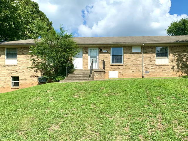 a view of a house with backyard and a garden