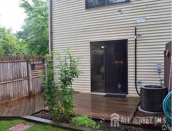 a view of a house with backyard and wooden fence