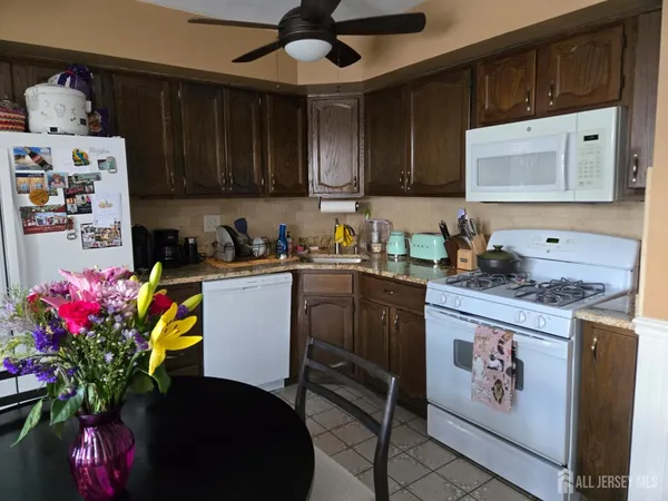 a kitchen with stainless steel appliances granite countertop a stove a sink dishwasher and cabinets with wooden floor