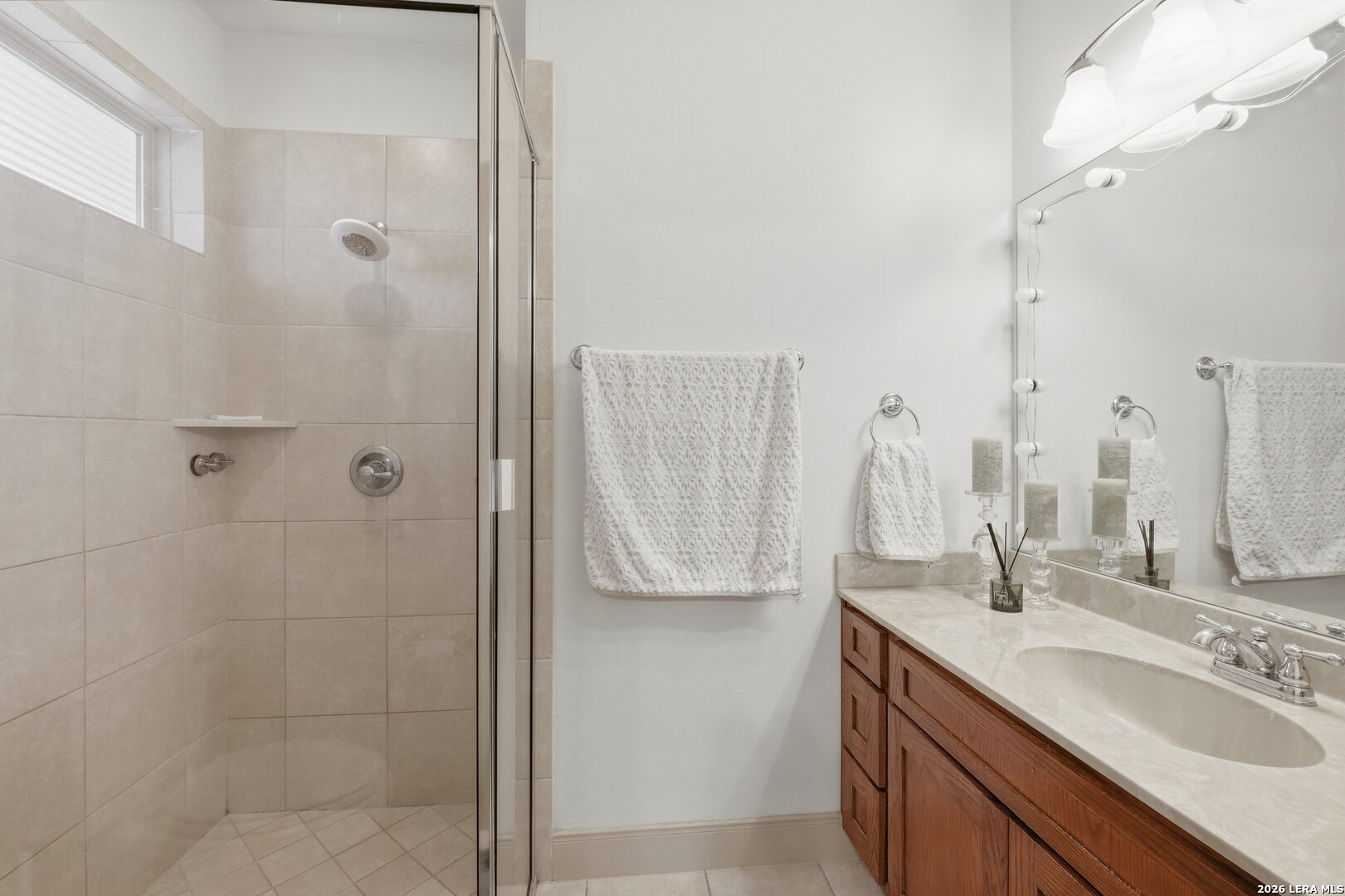 426 Legacy Ridge San Antonio, TX 78258 - Photo 22 of 38 a bathroom with a double vanity sink a shower and a mirror