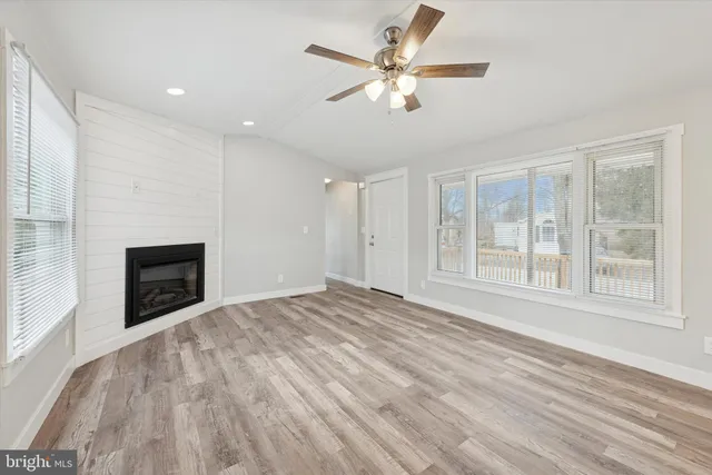 a view of an empty room with a fireplace and a window