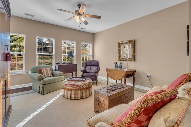 a living room with furniture ceiling fan and a window